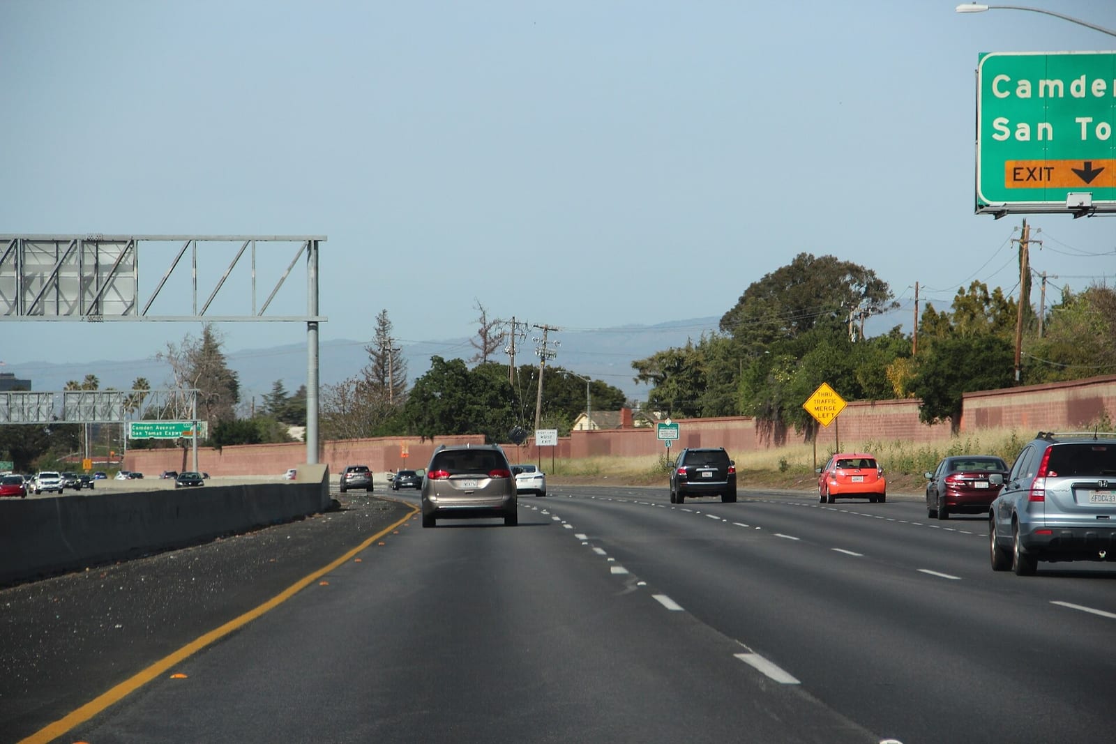 Traffic on California State Route 17 on a clear day, with overhead exit signs